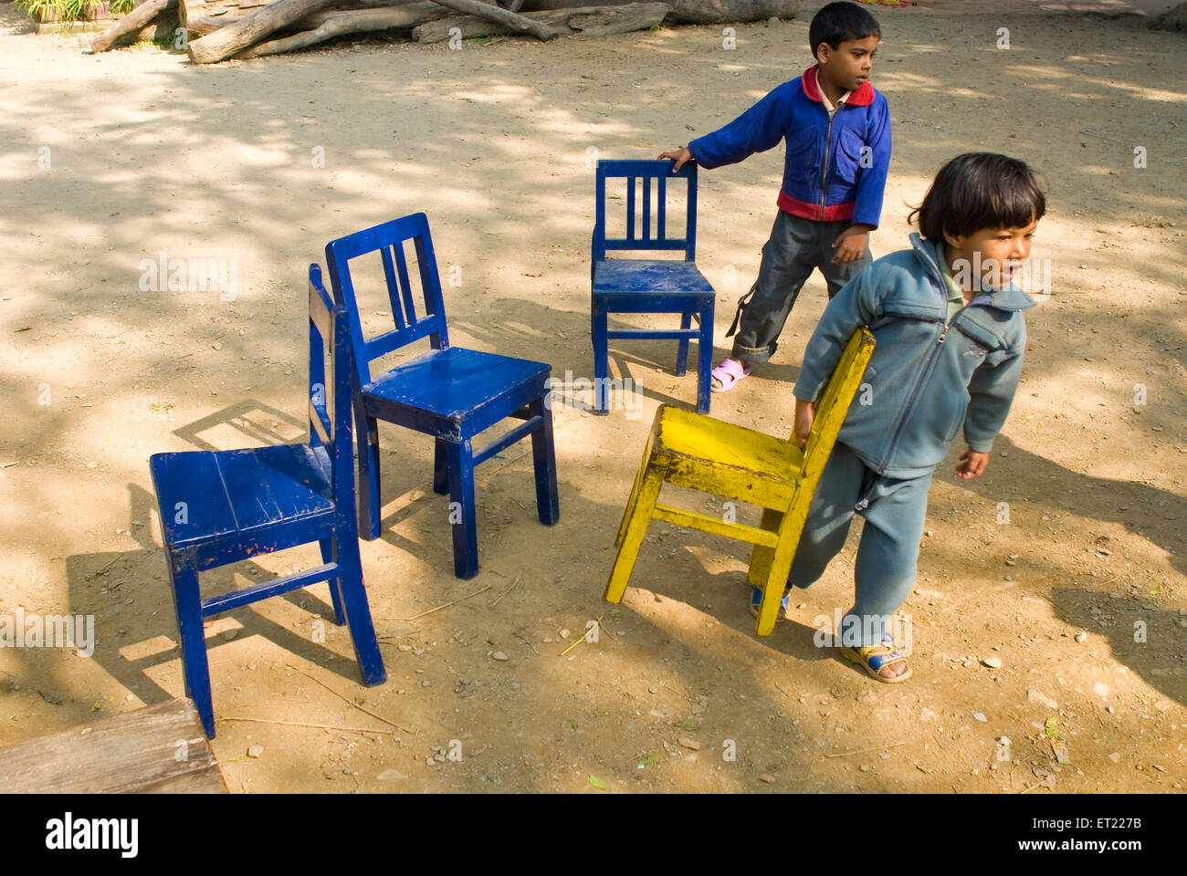 Garçon et une fille en faisant glisser les petites chaises ; Nanhi ; école Duniya Dehra Dun ; Uttarakhand Uttaranchal Inde ; M.# 711 Banque D'Images