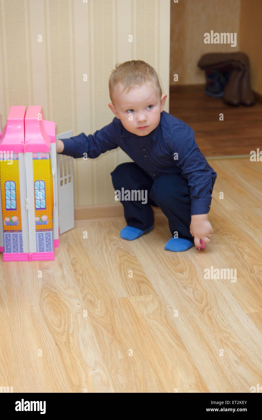 Le petit garçon joue avec un jouet lodge en chambre Banque D'Images