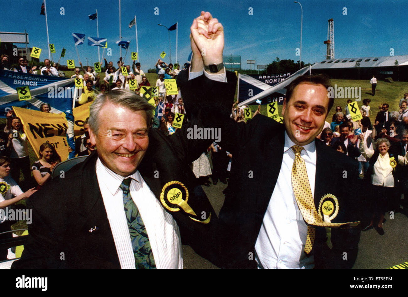 Alex Salmond, le leader du SNP ascenseurs Allan Macartney bras après sa victoire stupéfiante. 4 juin 1994. Banque D'Images