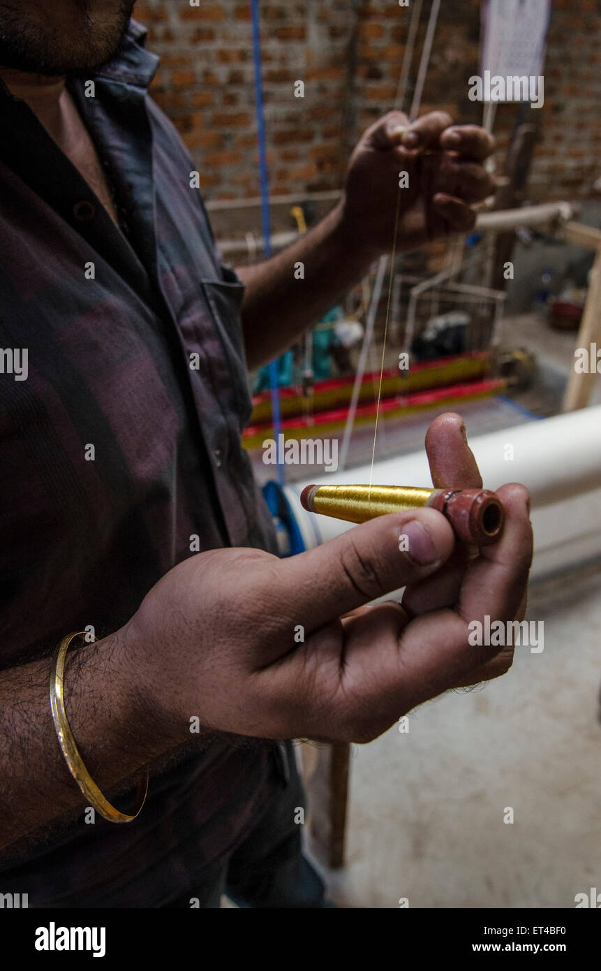 Un homme montre le fil d'or utilisé pour le traditionnel métier à main Balaramapurum à Sari, Inde Banque D'Images