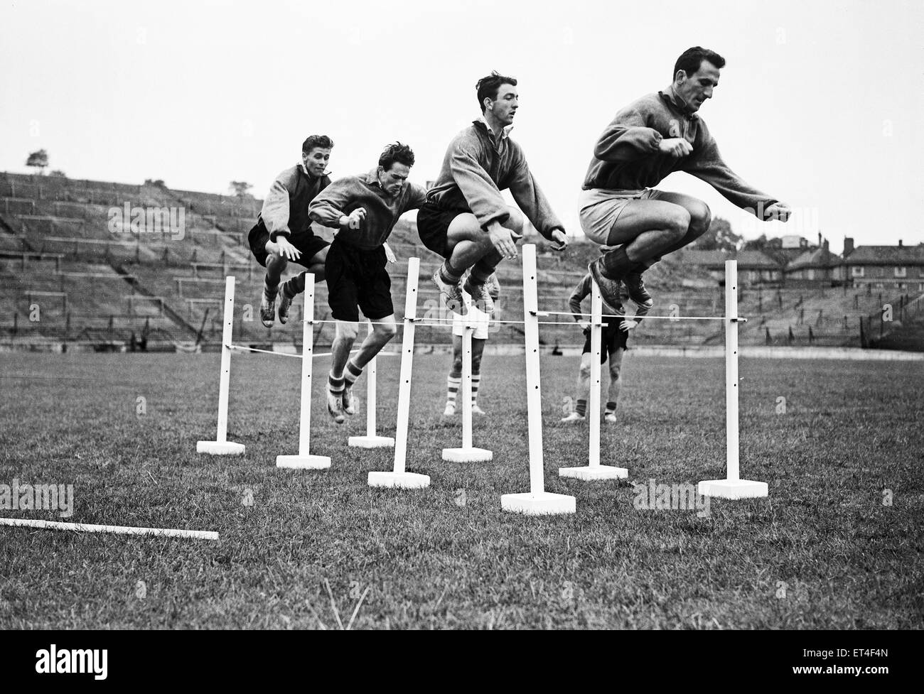 Exercices d'entraînement de l'équipe Charlton Athletic à la vallée. Les joueurs pratiquant leur capacité de saut comme ils sautent par-dessus les obstacles. Deuxième à droite est striker Eddie sentais Firmani, qui a compté 25 buts en tant que No10 au cours de la saison 1954-1955. 9 août 1954. Banque D'Images