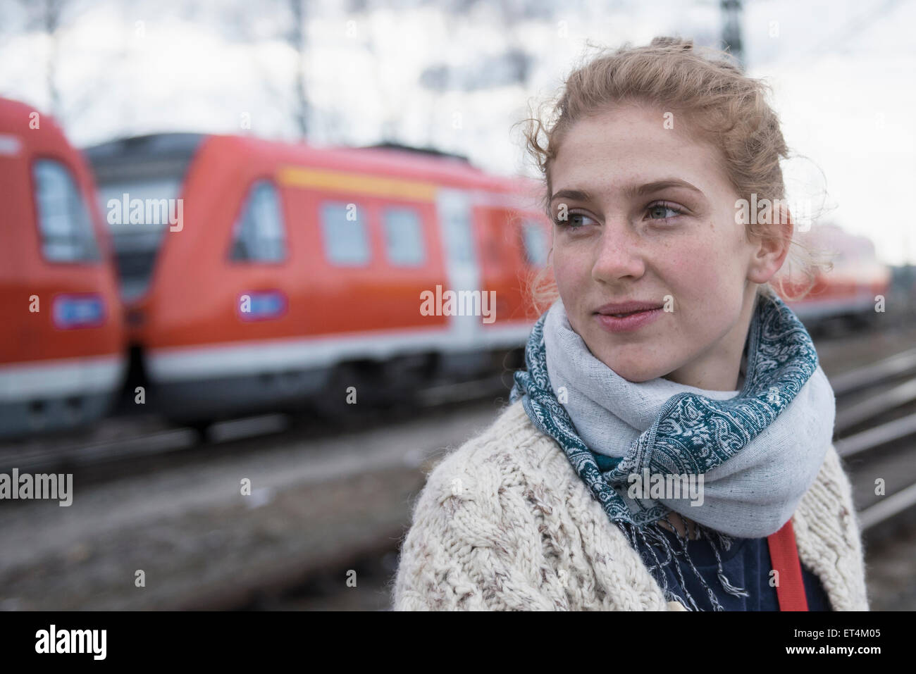 Portrait d'une jeune femme avec voie de chemin de fer et du train dans l'arrière-plan Banque D'Images