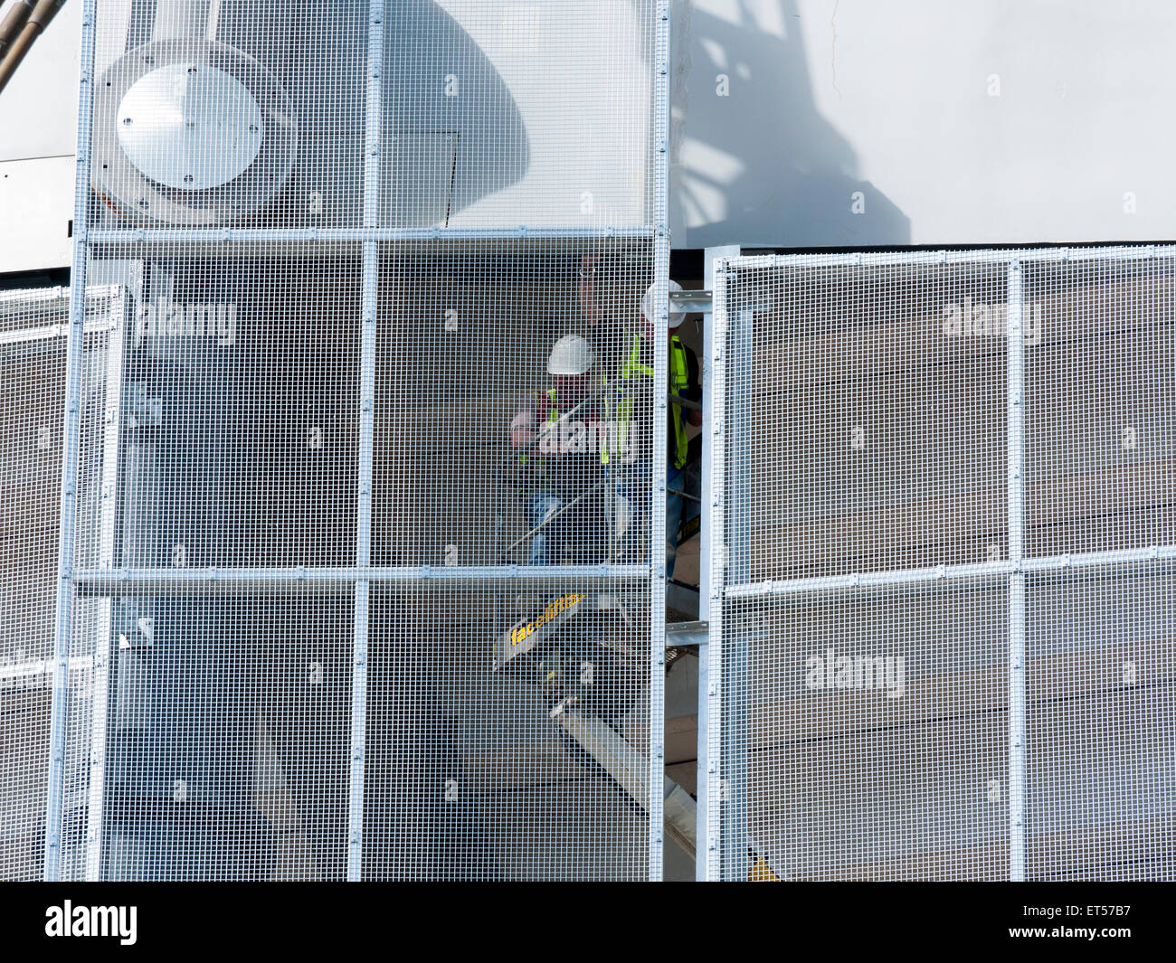 Des ouvriers sur une plate-forme d'accès de l'installation des panneaux à mailles, tribune sud travaux d'agrandissement, l'Etihad Stadium, Manchester, Angleterre, RU Banque D'Images