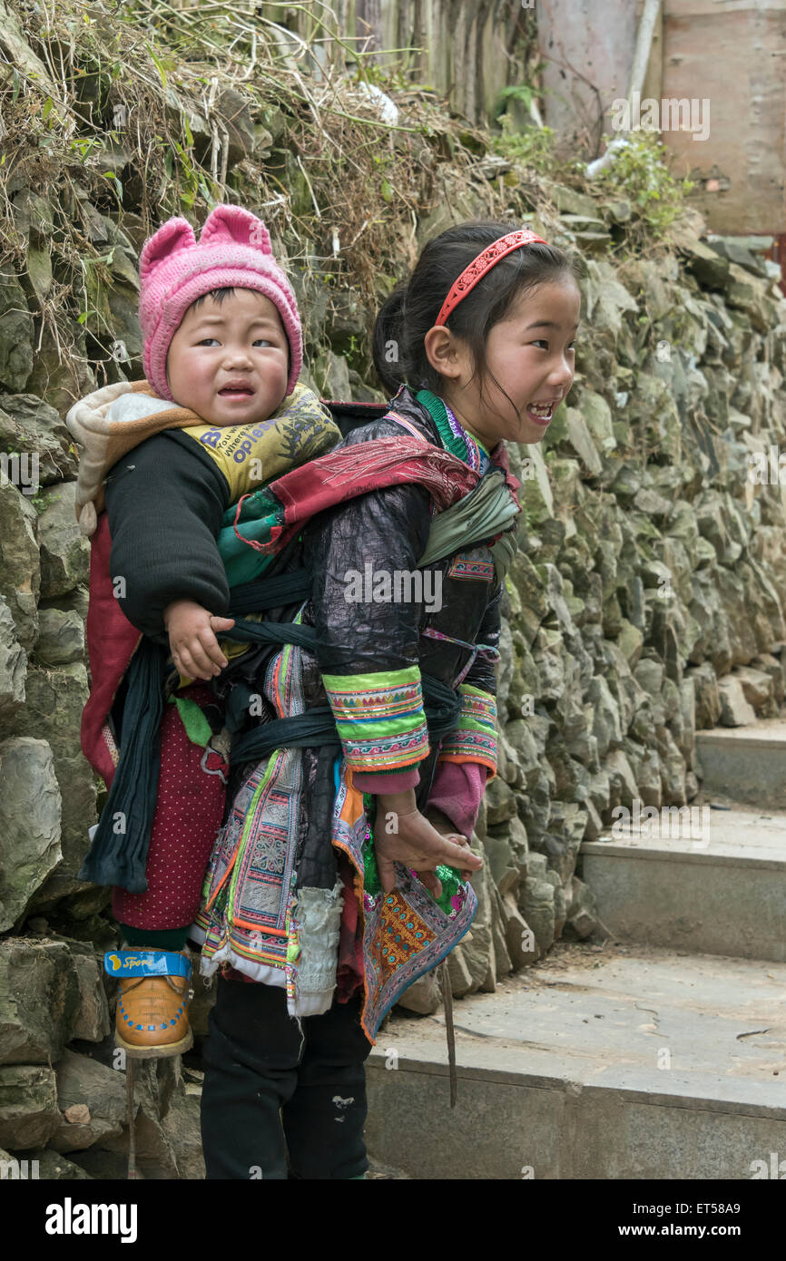 Petite fille Miao Basha avec un grand frère plus jeune sur son dos, Basha Village des armes à feu, la province du Guizhou, Chine Banque D'Images