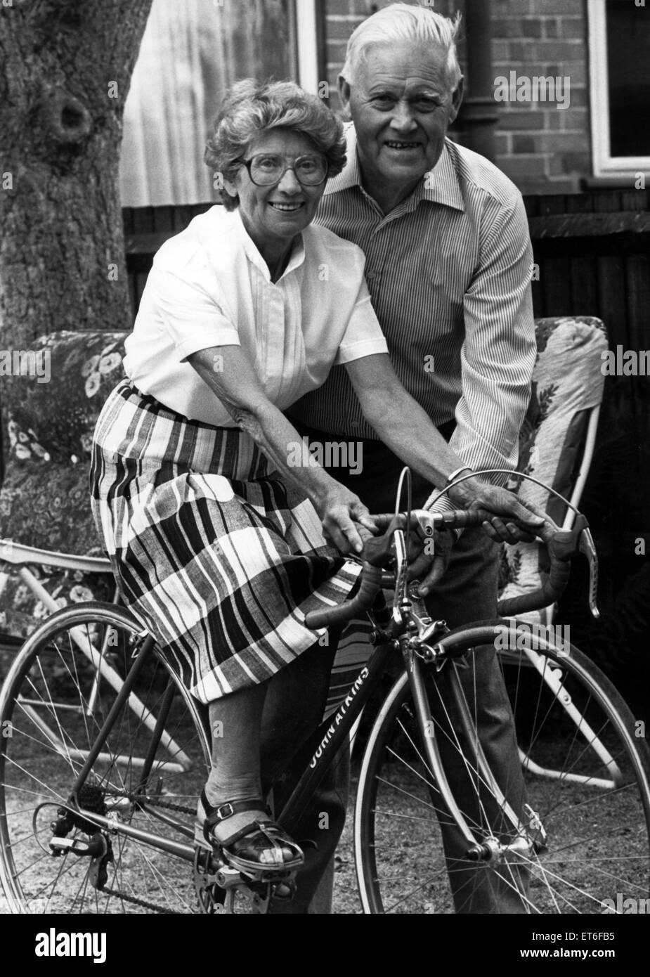 Couple à vélo et Edith Ron Atkins célèbrent 50 ans de bicyclette bliss réunit aujourd'hui. La paire ont une maison ouverte et espérons que vos amis et famille vous souhaitons bon sur leurs noces d'or. 26 juillet 1990. Banque D'Images