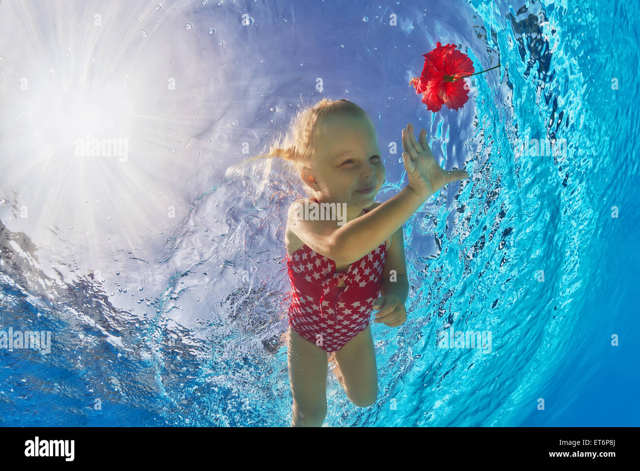 Heureux Petit Bebe Avec Sourire Et Ouvrir Les Yeux Sous L Eau Plongee Dans L Eau Bleue Et Claire Pour Une Fleur Rouge Vif Photo Stock Alamy