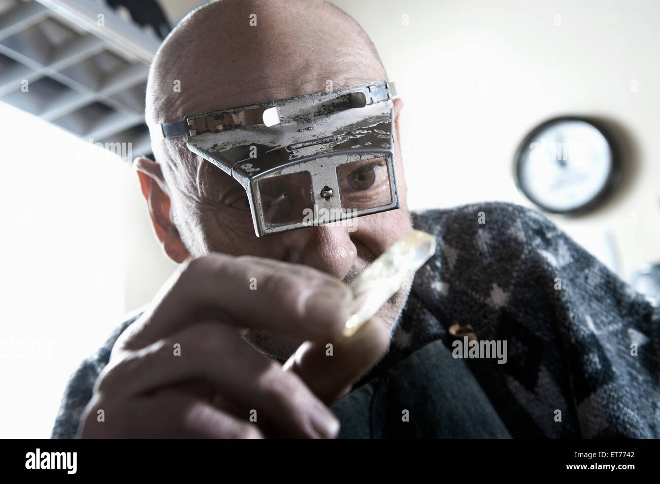 Senior male goldsmith à la recherche de crystal, Bavière, Allemagne Banque D'Images