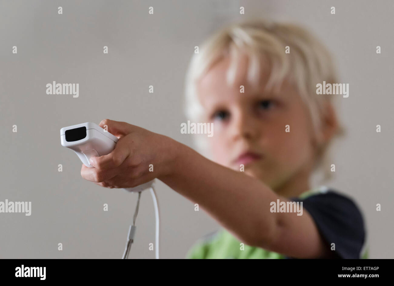 7 ans à la maison de jeu d'ordinateur de jeu Nintendo Wii avec Nintendo contrôleur de jeu dans sa main. Banque D'Images