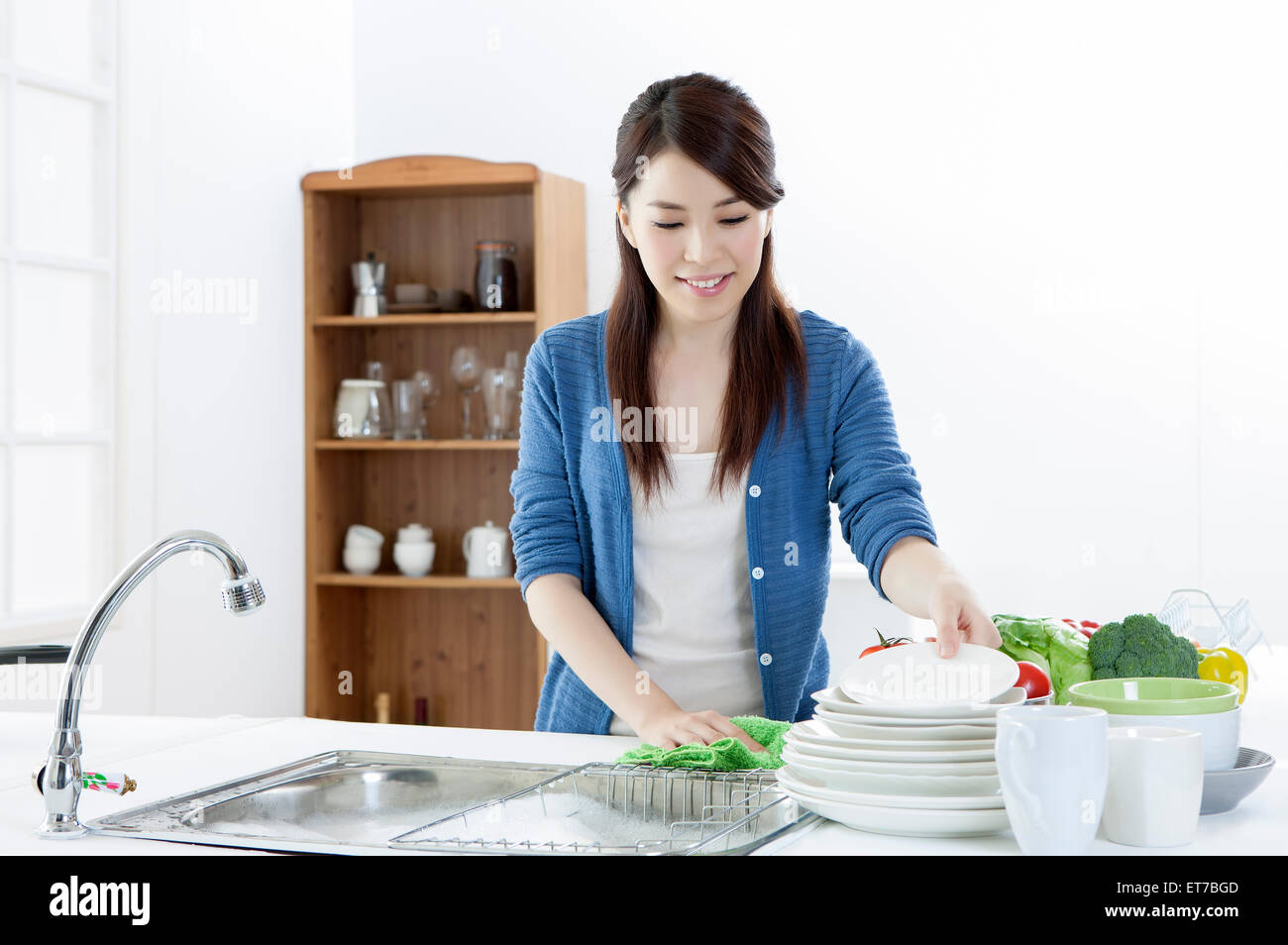 Jeune femme à la recherche vers le bas et lave-assiettes Banque D'Images