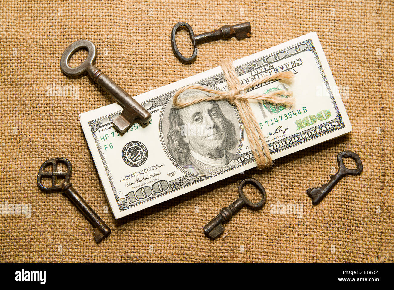Un paquet de dollars attaché avec une corde et des clés dans le vieux tissu Banque D'Images