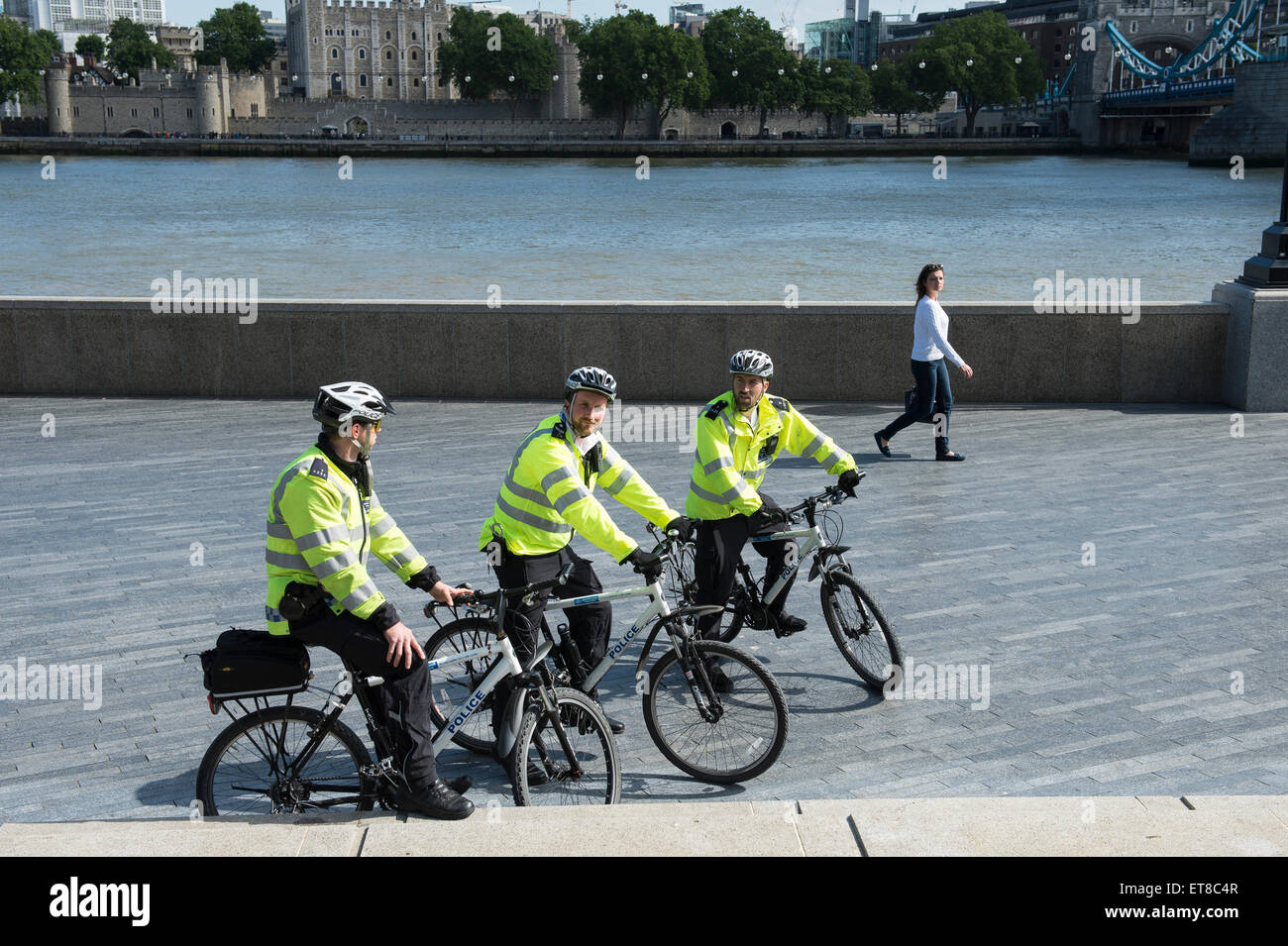 Ville de London policiers sur des vélos de montagne en face de Tower Bridge par la Tamise Banque D'Images