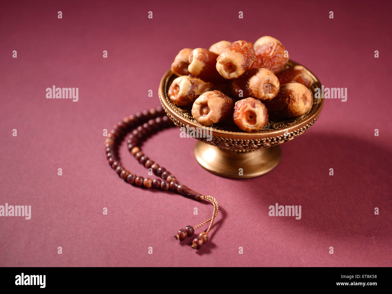 Les dates dans un bol et perles de prière islamique. Banque D'Images