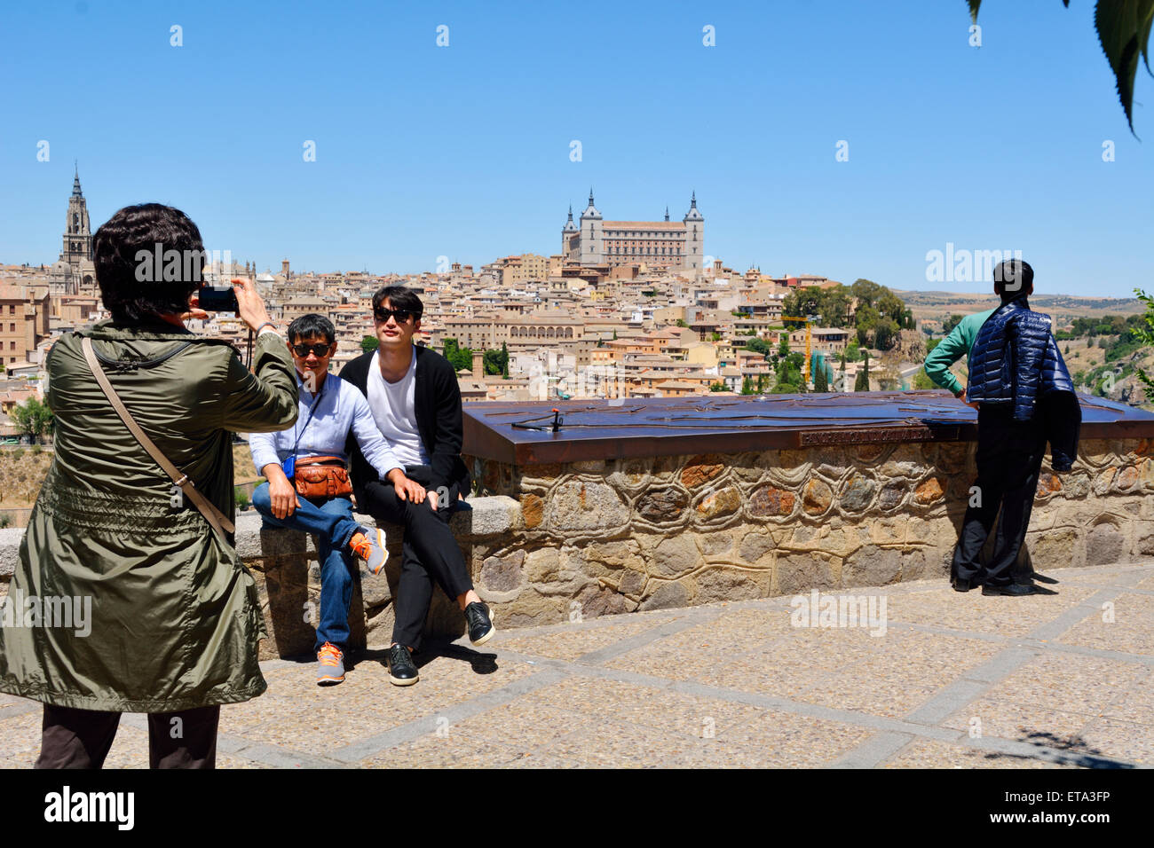 Touriste avec téléphone appareil photo en prenant la photo d'amis à vue surplombant Toledo, Espagne Banque D'Images