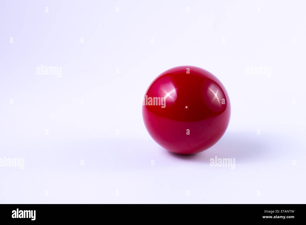 Une boule de billard rouge sur fond blanc Banque D'Images
