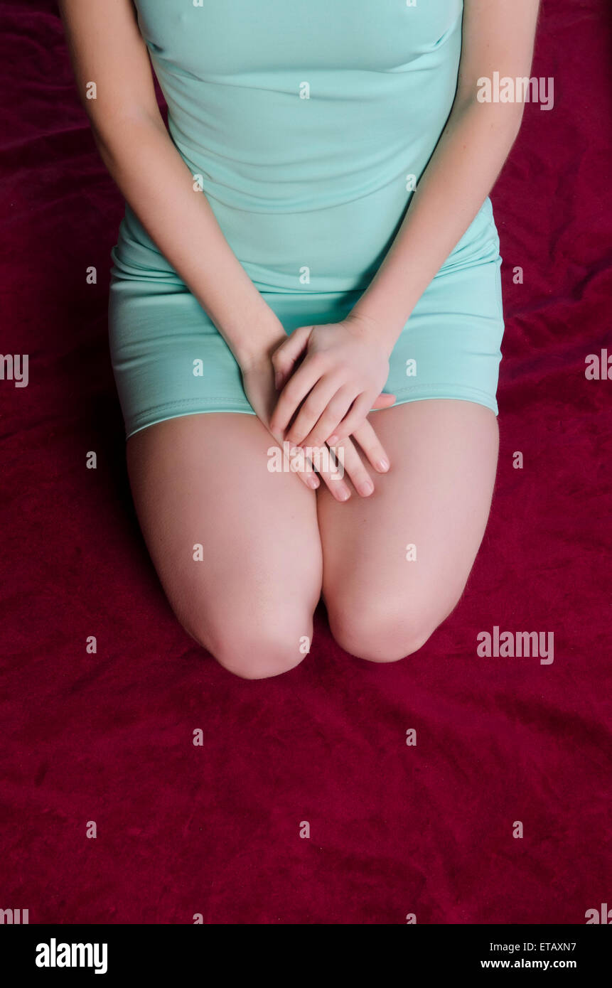 Femme en robe verte courte sat on bed Banque D'Images