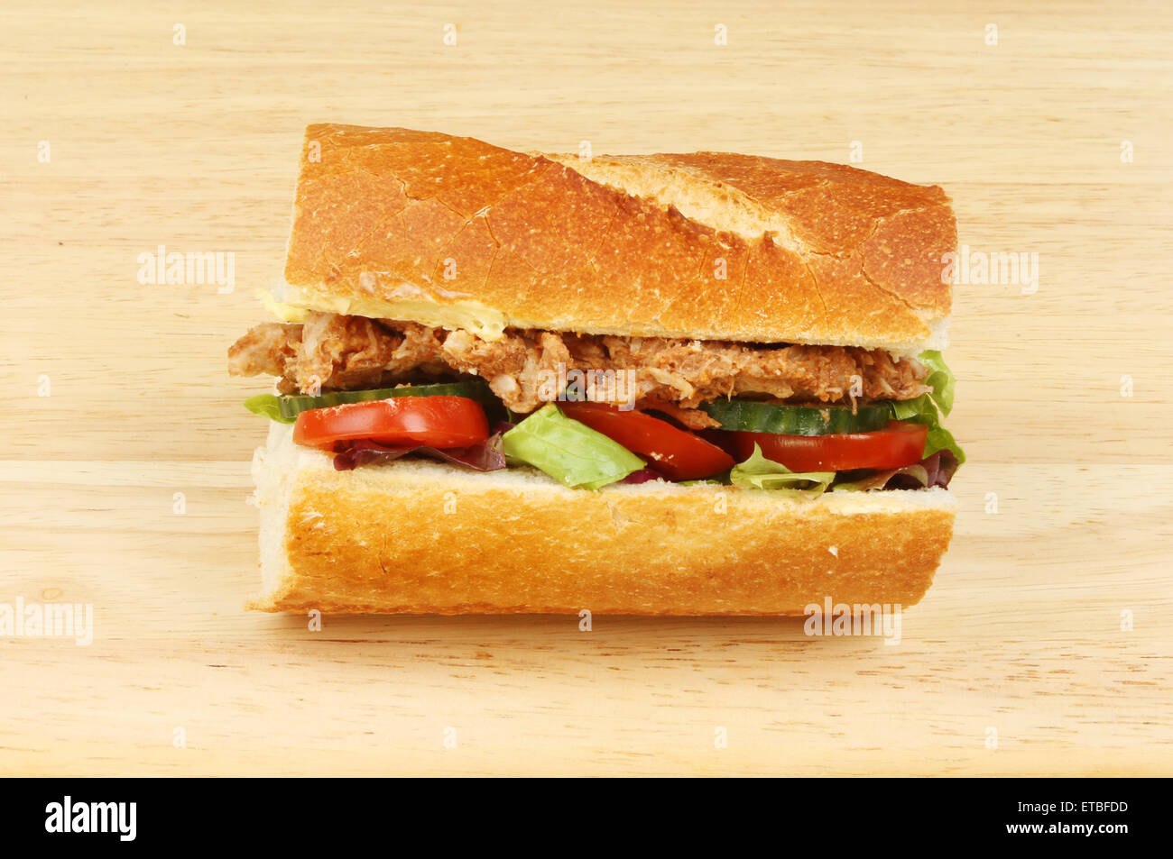 Salade de porc et du pain croûté dans un rouleau sur une planche en bois Banque D'Images