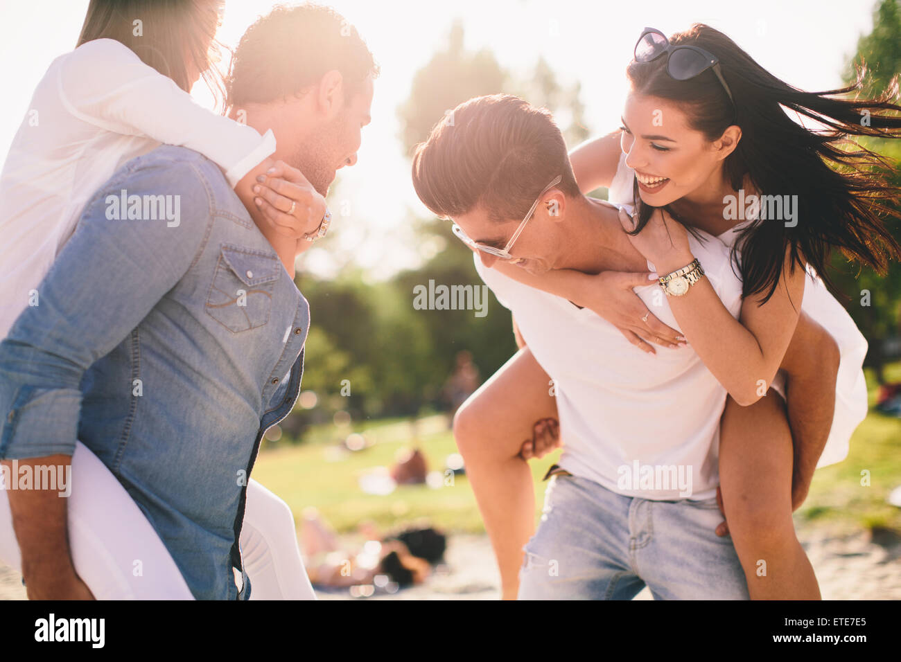 Les jeunes couples s'amusant sur la plage Banque D'Images
