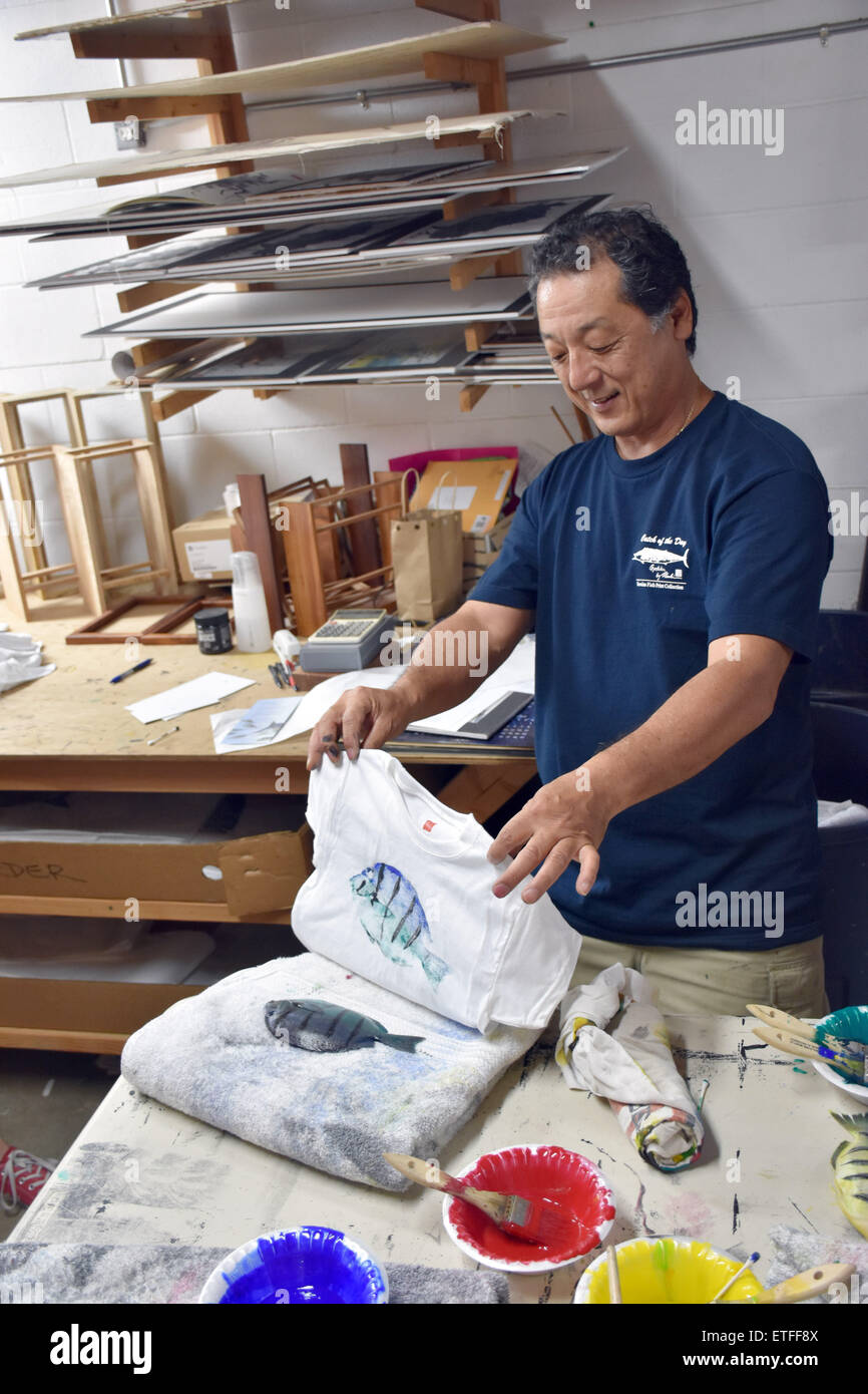 Artiste hawaïen Naoki Hayashi présente l'une de ses oeuvres, un t-shirt, dans son atelier à Kaneohe sur Oahu Island, USA, 10 mai 2015. Hayashi a transformé une ancienne technique d'impression de poissons japonais dans une forme d'art qui l'a aidé à attirer des clients de partout dans le monde. Photo : Chris Melzer/dpa Banque D'Images