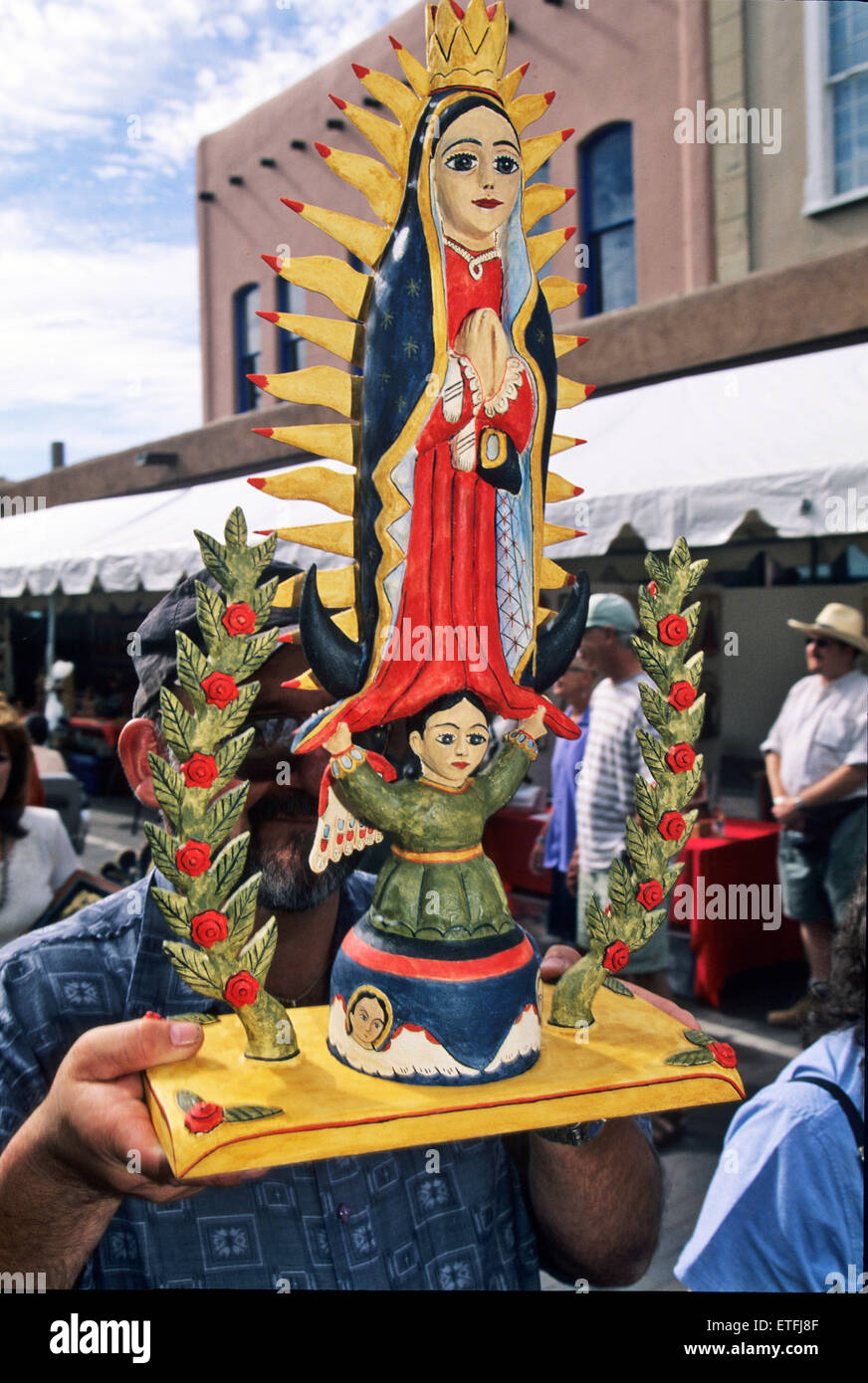 Ernie artiste palans Lujan sa sculpture en bois peint (appelé bulto en espagnol) de la Vierge de Guadalupe au cours du dimanche matin Banque D'Images