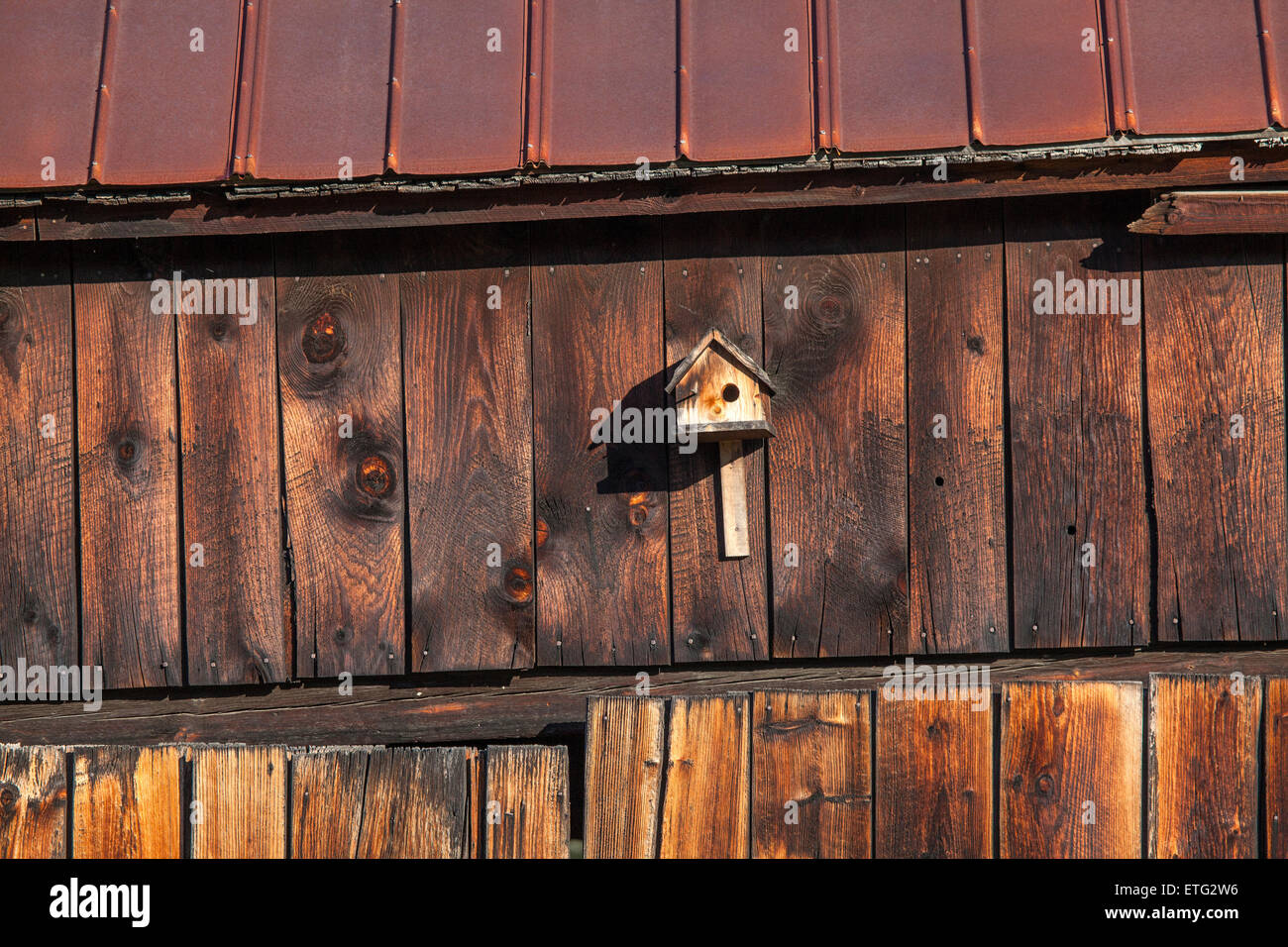 Une petite cabane sur le côté d'une ancienne grange. Beaucoup de weathered wood texture et profond, riche, de couleur brun-rougeâtre. Banque D'Images