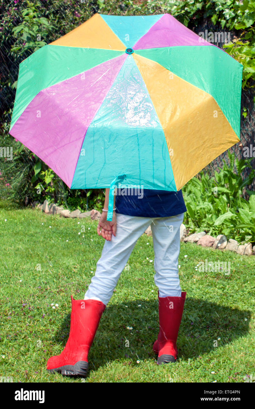 Une petite fille avec un unbrella dans un beau jour de pluie Banque D'Images