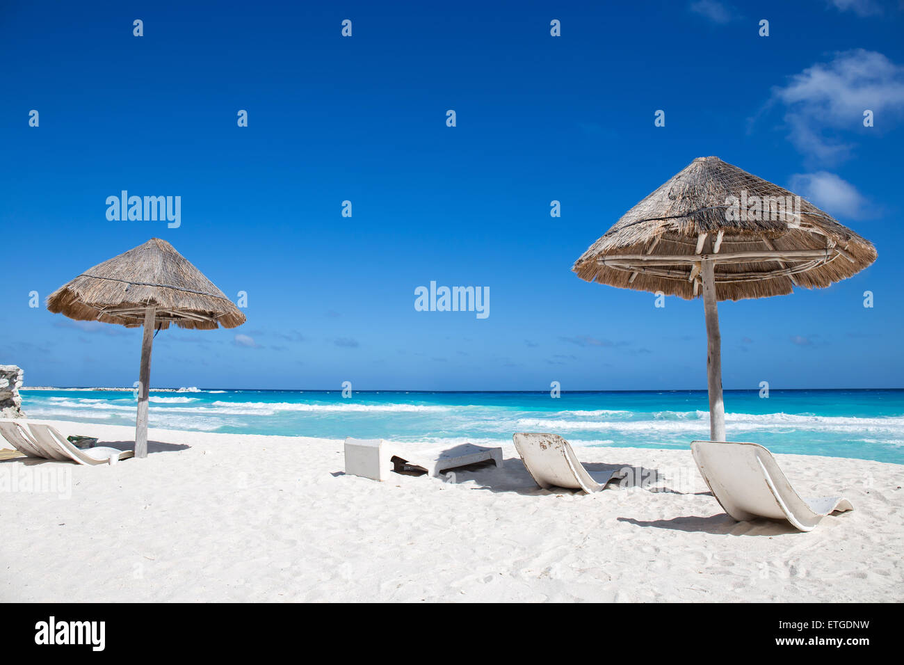 Côte de la mer des Caraïbes avec l'herbe de parasols et lits de plage en bois. Locations de concept Banque D'Images