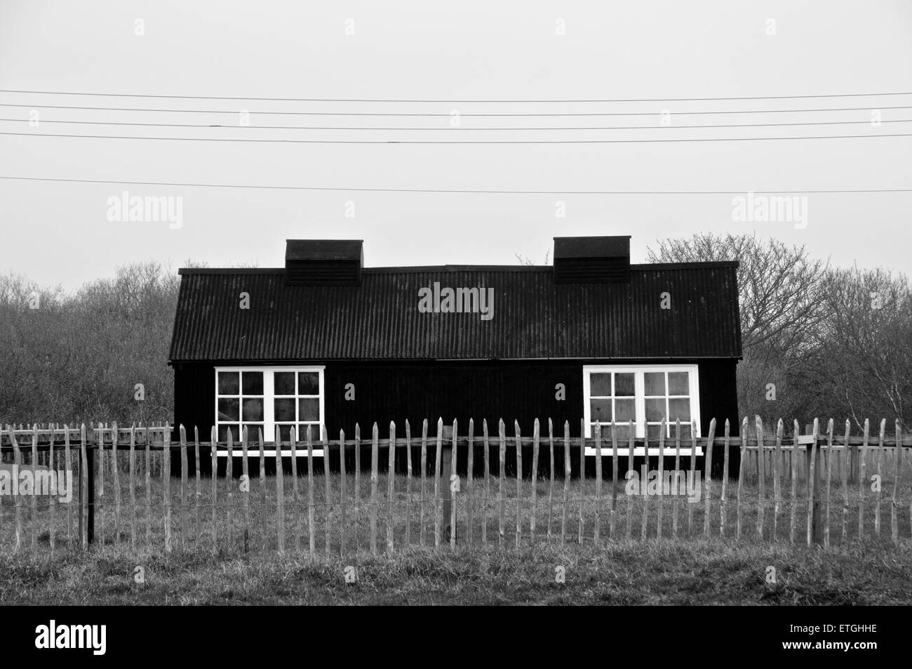 Ancienne cabane de pêcheur avec une clôture en bois et une ligne électrique rénové comme un cottage de vacances East Anglia Suffolk Angleterre Angleterre Europe Banque D'Images