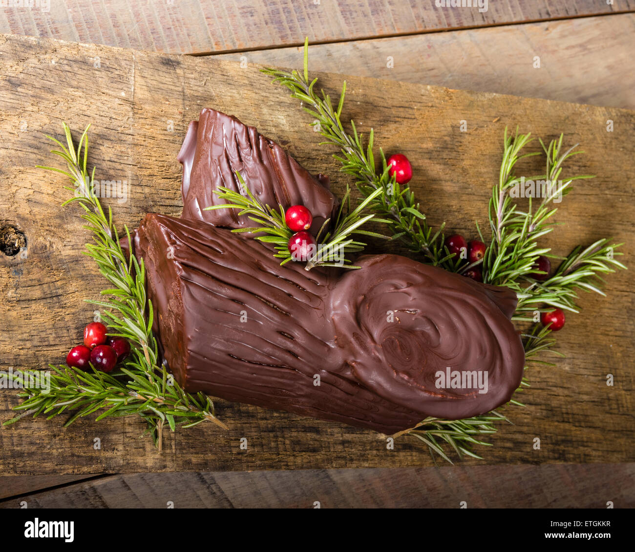 Bûche au chocolat avec des branches vertes et canneberges Banque D'Images