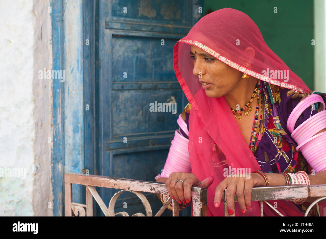 Femme en sari Rajasthani colorés à la porte de son village, près de Jodhpur, Inde Banque D'Images