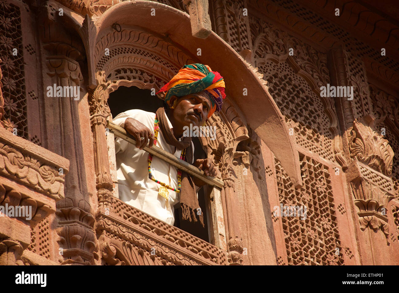 L'homme du Rajasthan à partir de fenêtre en façade sculptée à Fort Mehrangarh, Jodhpur, Rajasthan, India Banque D'Images