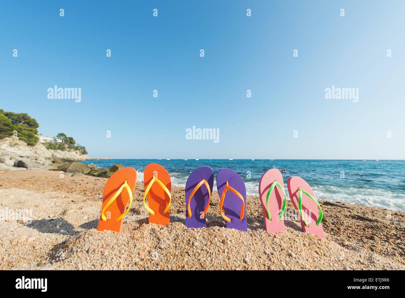 Tongs colorées de rangs à la plage Banque D'Images