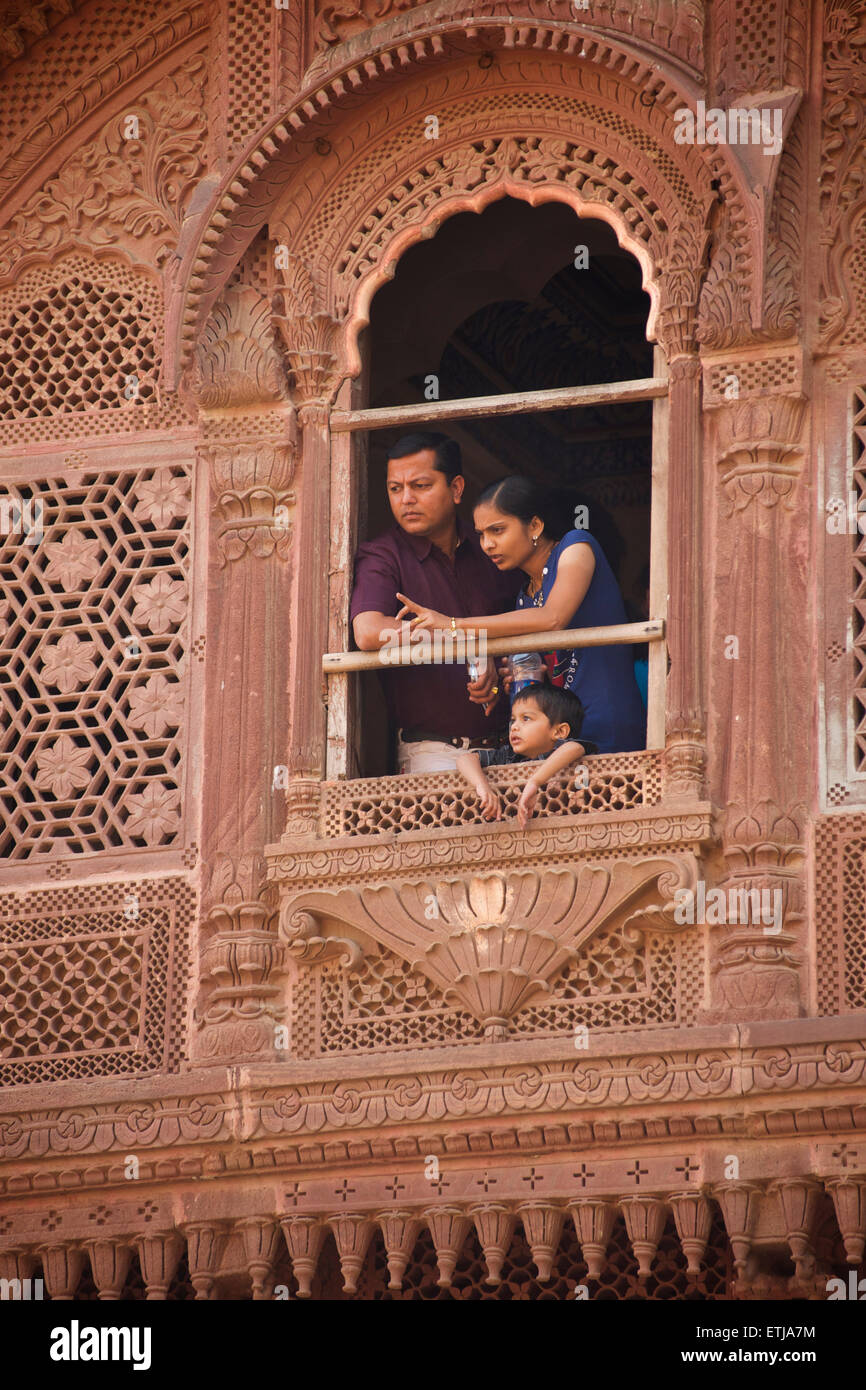 Famille indienne à partir de fenêtre en façade sculptée à Fort Mehrangarh, Jodhpur, Rajasthan, India Banque D'Images