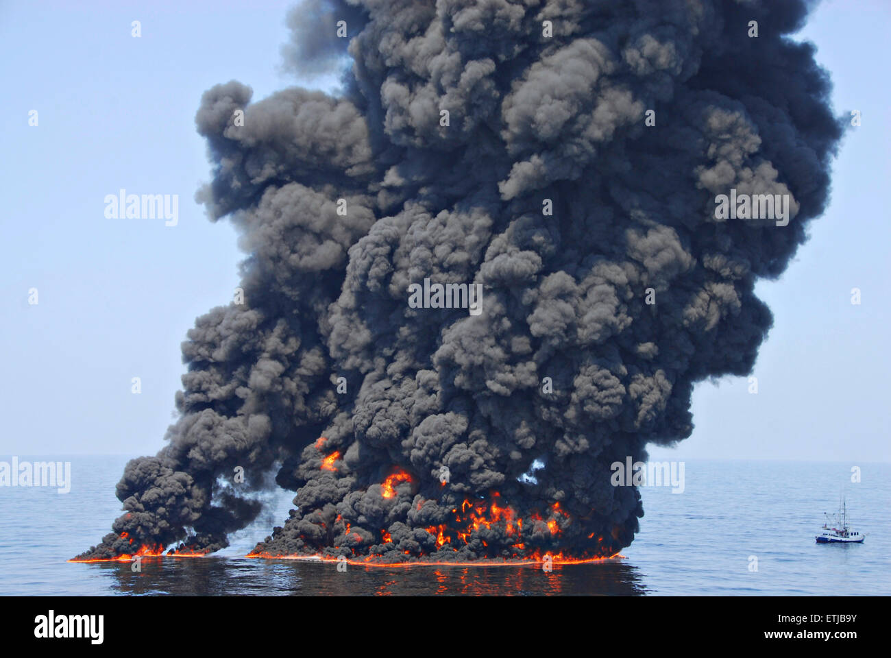 Les nuages sombres comme le ciel des équipages nettoyer un brûlage contrôlé d'huile recueillie à partir de la surface du golfe du Mexique à la suite de la marée noire Deepwater Horizon de BP la catastrophe que les efforts déployés pour contenir et nettoyer les millions de gallons d'équipage continuent le 9 juin 2010 dans le golfe du Mexique. Banque D'Images