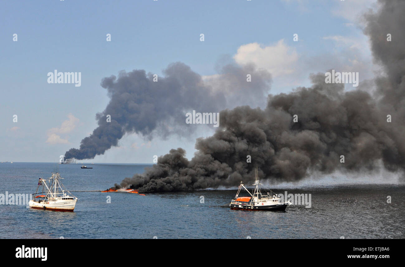 Les nuages sombres comme le ciel des équipages nettoyer un brûlage contrôlé d'huile recueillie à partir de la surface du golfe du Mexique à la suite de la marée noire Deepwater Horizon de BP la catastrophe que les efforts déployés pour contenir et nettoyer les millions de gallons d'équipage continuent le 17 juin 2010 dans le golfe du Mexique. Banque D'Images