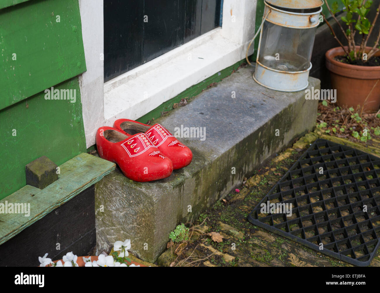 Paire de chaussures en bois rouge en face d'une porte Banque D'Images