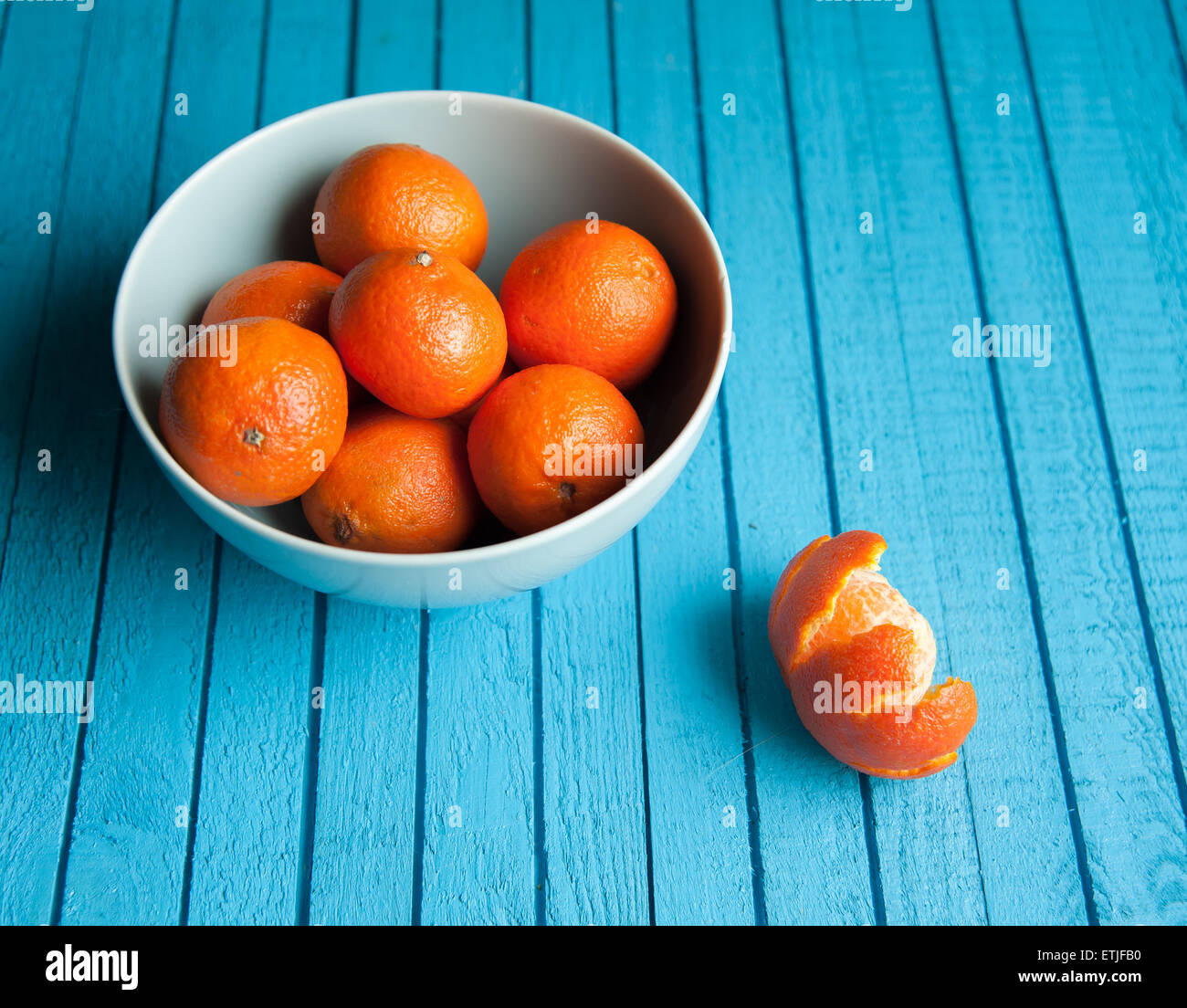 De nombreux la mandarine se situent sur une table en bois, bleu Banque D'Images