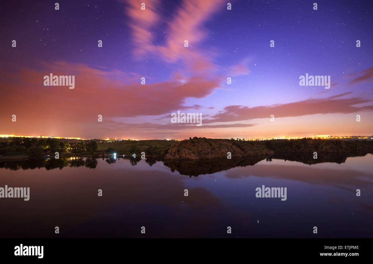 Beau ciel nocturne à la rivière avec des étoiles, des nuages et des reflets dans l'eau. L'été à l'Ukraine Banque D'Images