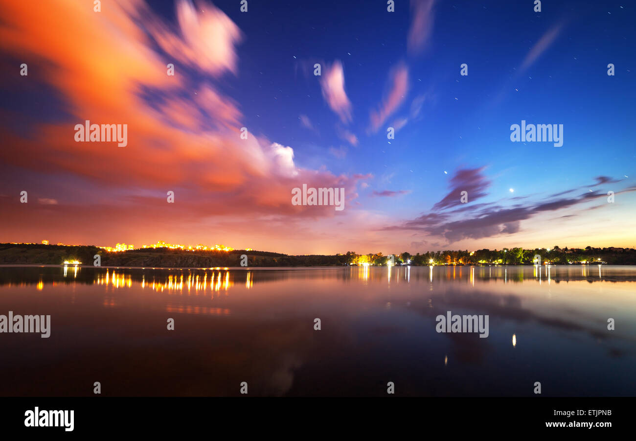Beau ciel nocturne à la rivière avec des étoiles, des nuages et des reflets dans l'eau. L'été à l'Ukraine Banque D'Images