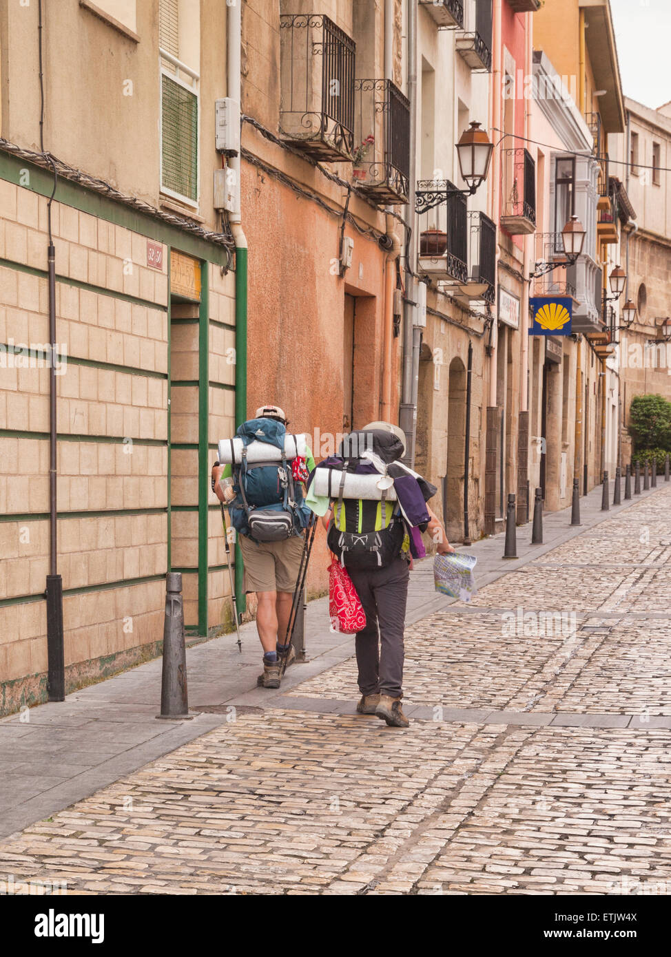 Back packers marche dans une rue de Logroño, La Rioja, Espagne, vers une coquille Saint-Jacques signe, qui est la cote officielle pour... Banque D'Images