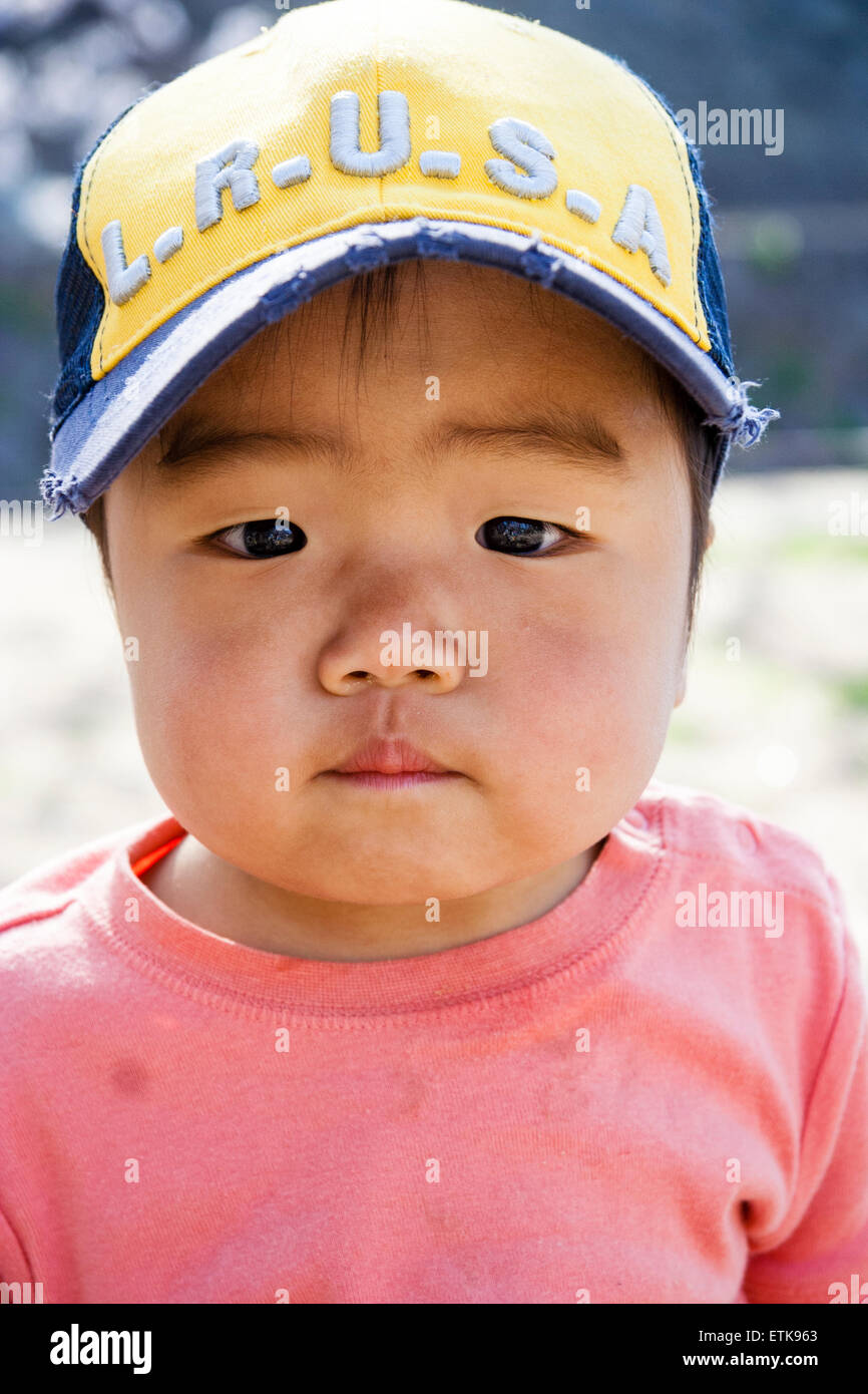 Enfant japonais, garçon, 4-5 ans, avec expression en colère. Gros plan, tir  à la tête, port d'une casquette de baseball. Contact visuel avec le  visualiseur. À l'extérieur Photo Stock - Alamy