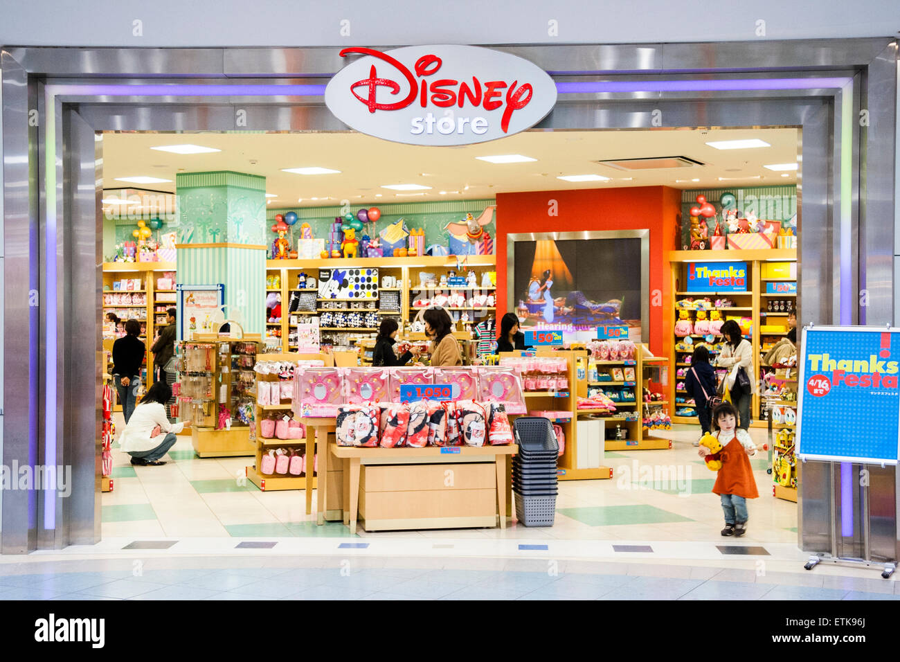 Japon, Nishinomiya. Intérieur d'un centre commercial moderne. Magasin Disney, stands d'exposition et boutiques de personnes, petite fille debout à l'entrée. Banque D'Images