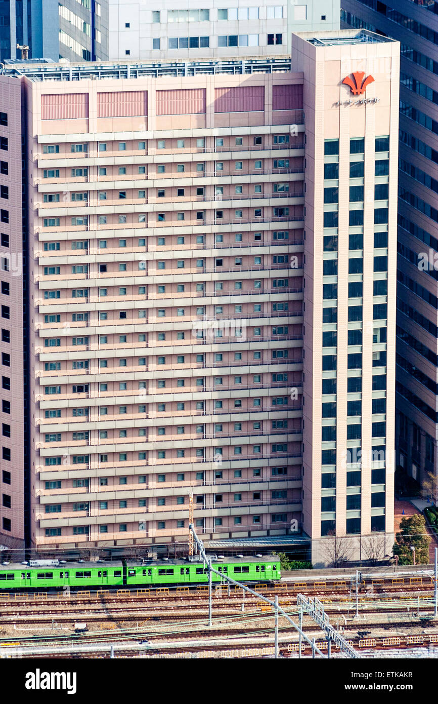 Japon, Osaka. Vue aérienne depuis l'Umeda Sky Building, un immeuble de bureaux de 20 étages dominant le chemin de fer avec un train en boucle vert d'Osaka qui passe devant. Banque D'Images
