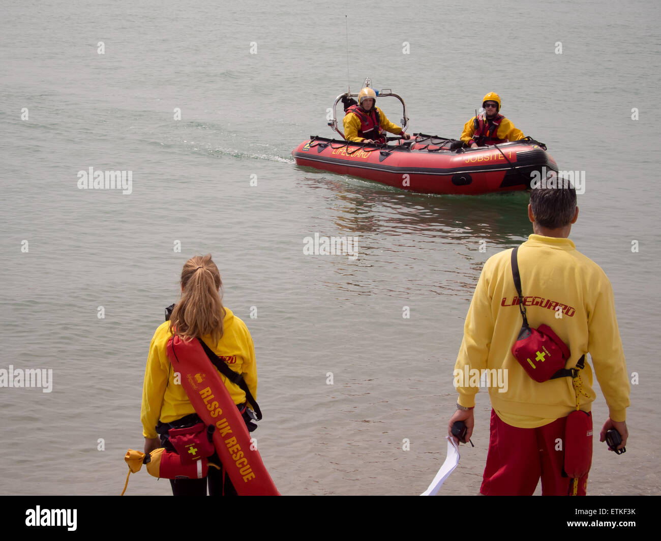 Comité permanent de sauveteurs sur la plage et dans une côte surveillent les baigneurs dans la mer Banque D'Images