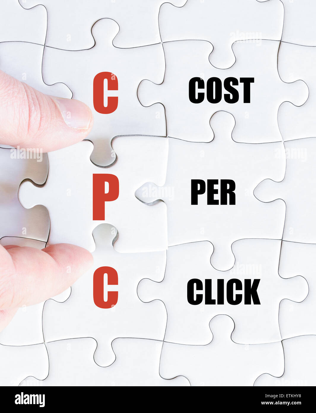 Main d'un homme d'affaires de remplir le puzzle avec la dernière pièce manquante.Concept image Acronyme PCC comme coût par clic Banque D'Images
