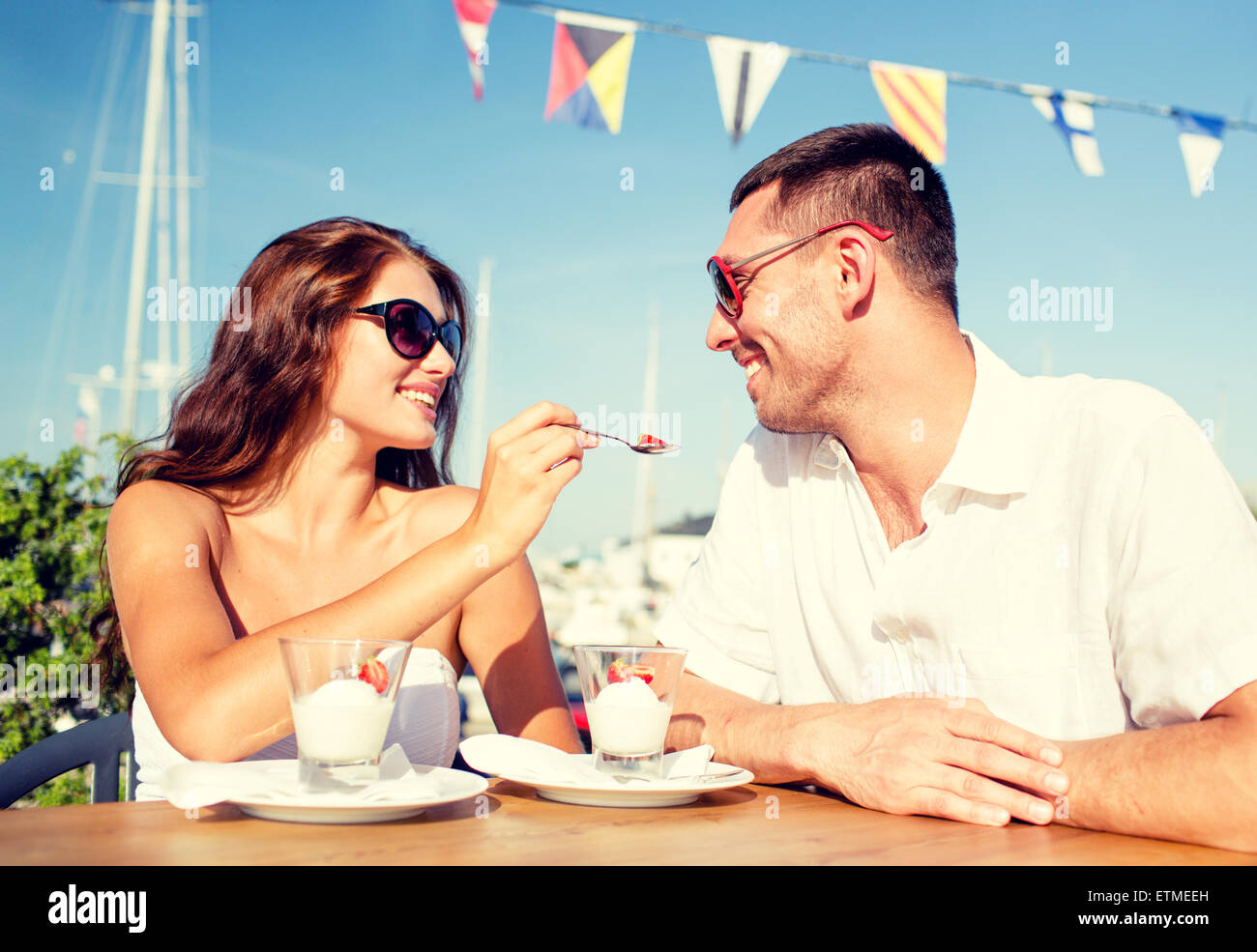 Smiling couple eating dessert au café Banque D'Images