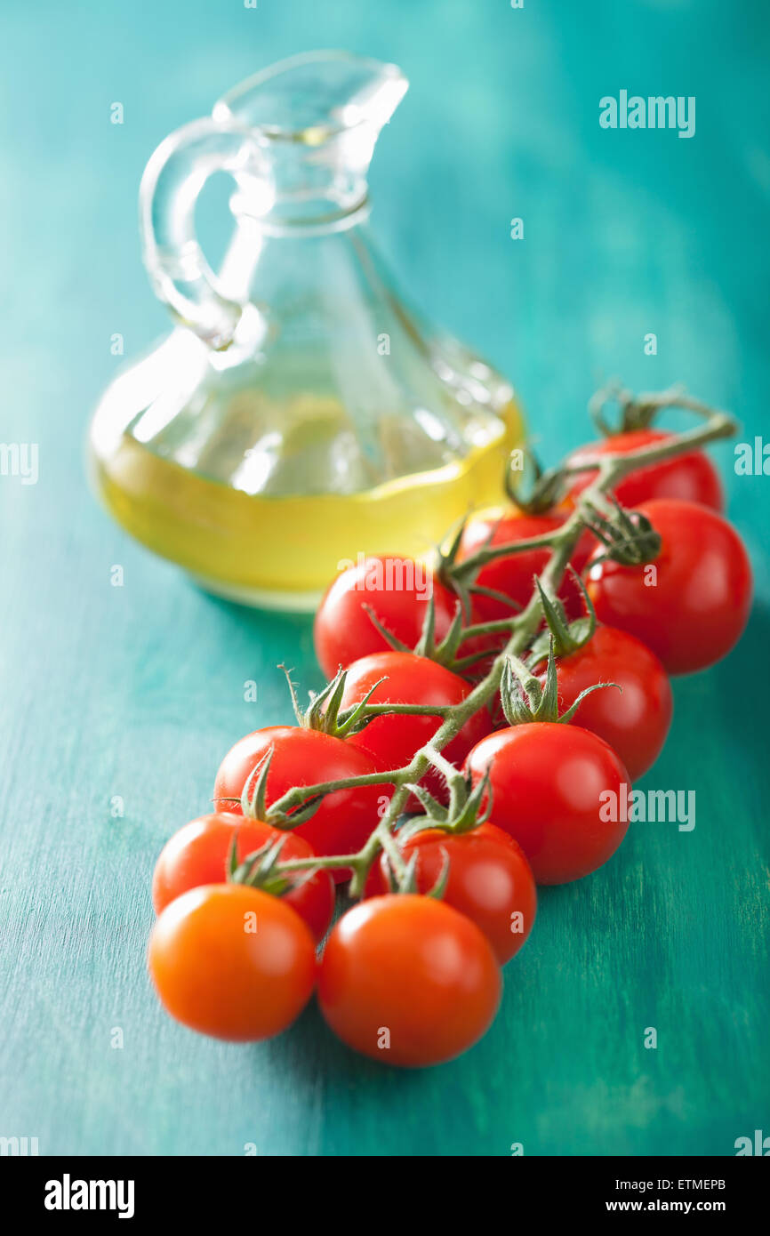 Les tomates cerises et huile d'olive sur fond bleu turquoise Banque D'Images