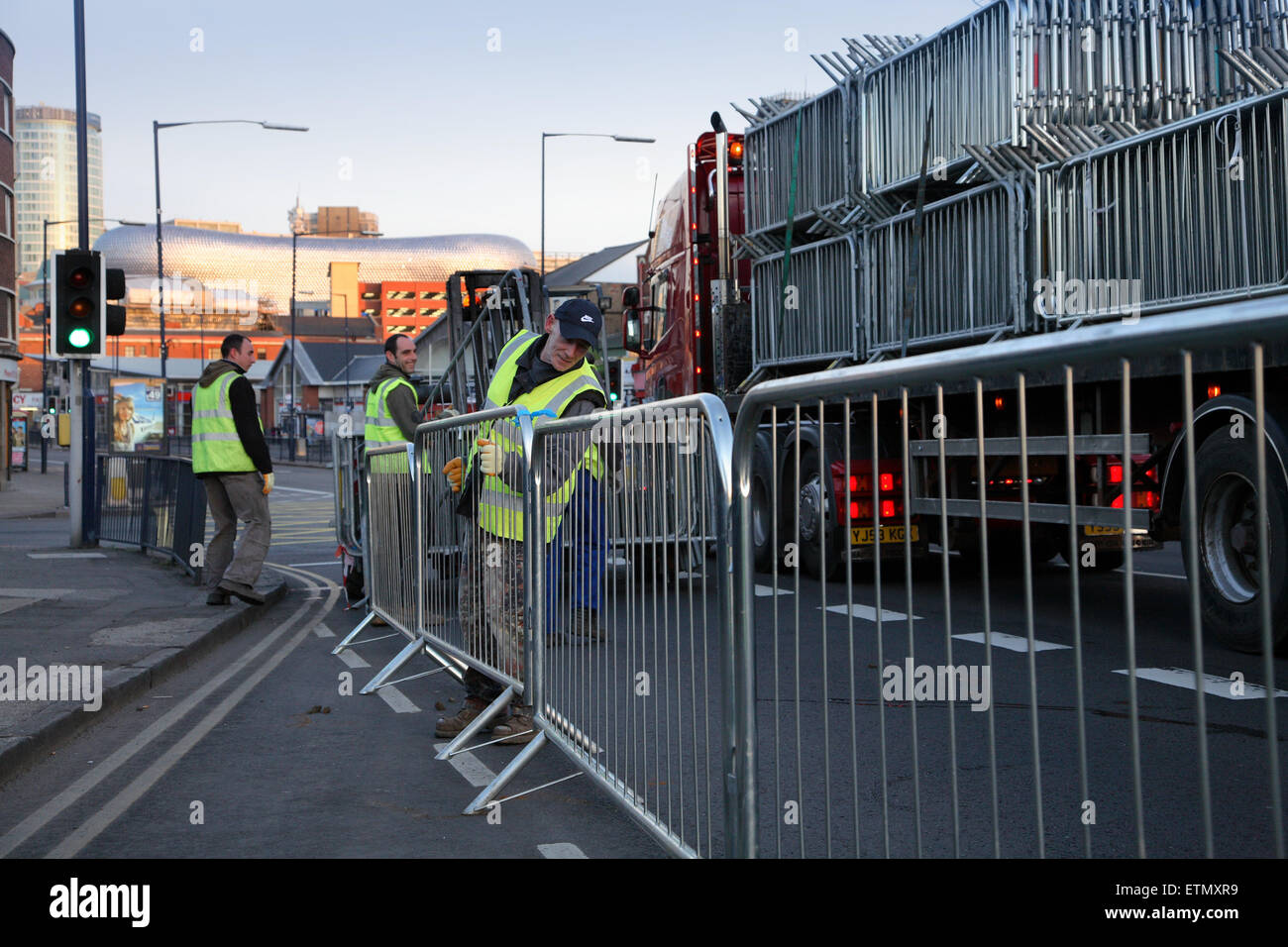 Ouvriers érigeant des barrières pour piétons à l'aube pour le St Patricks Day Parade à Birmingham Banque D'Images
