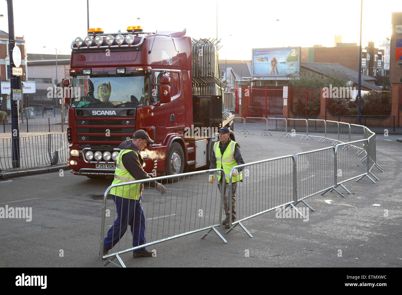 Ouvriers érigeant des barrières pour piétons à l'aube pour le St Patricks Day Parade à Birmingham Banque D'Images