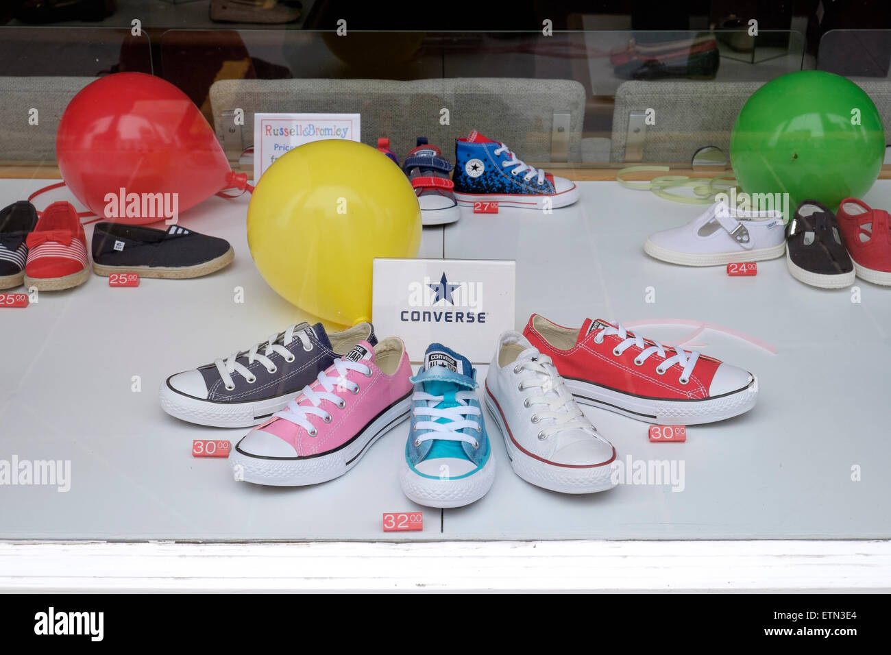 Chaussures Converse enfants affiché dans une fenêtre de magasin de chaussures Banque D'Images