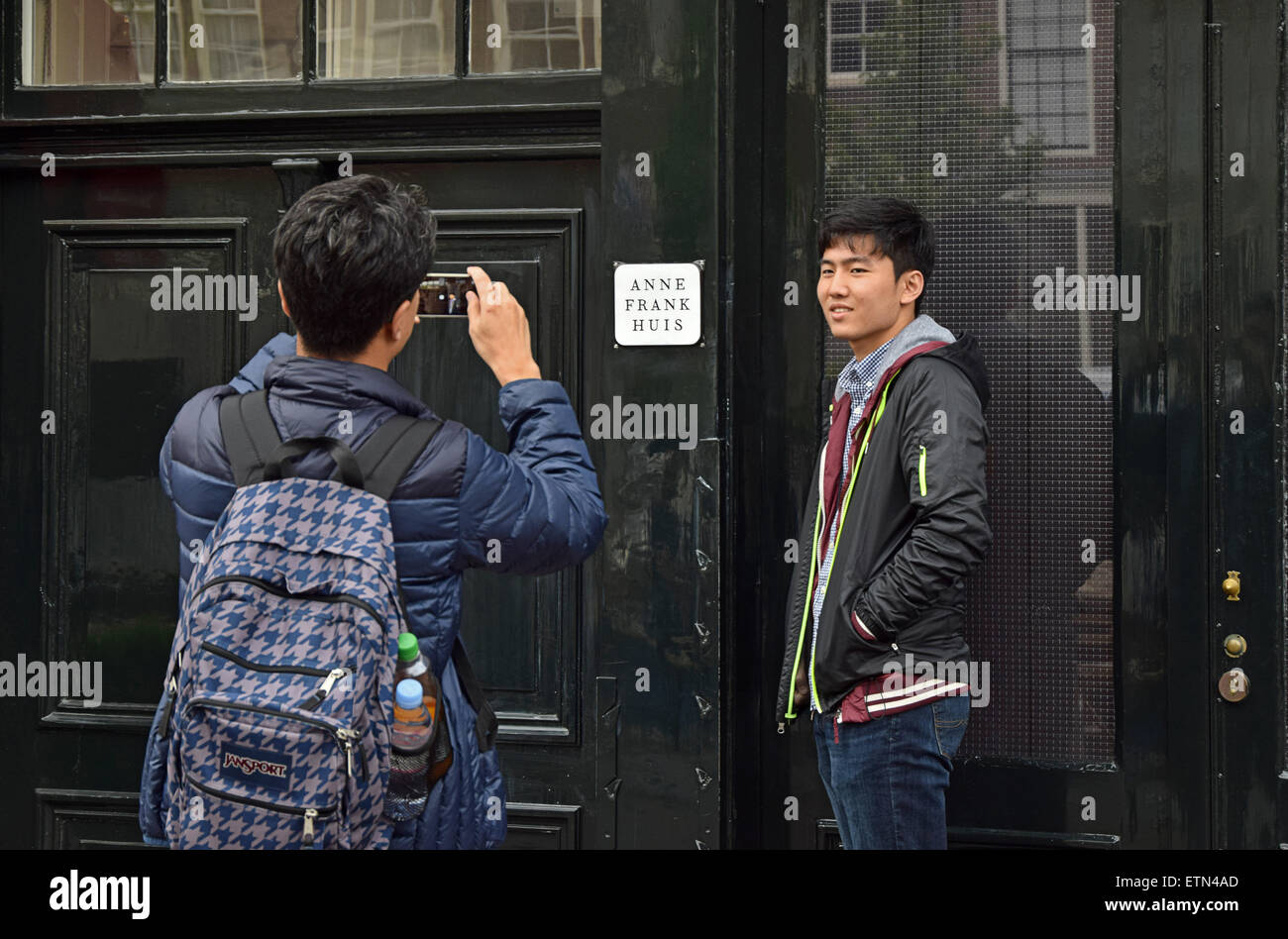 Un touriste asiatique ayant sa photo prise à l'extérieur de la maison d'Anne Frank à Amsterdam, Hollande. Banque D'Images